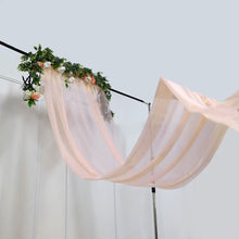 A blush sheer chiffon fabric curtain panel with flowers hanging from it