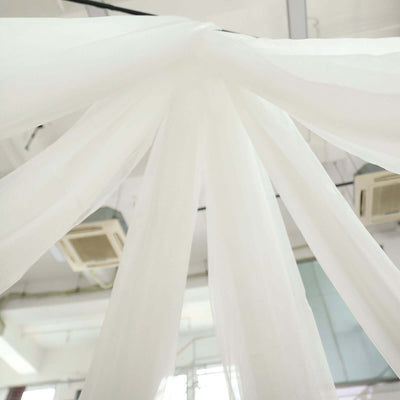 White sheer fabric draping from above in a bright, airy space.