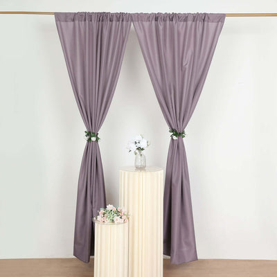 Elegant purple curtains draped with floral tiebacks in a studio setting.