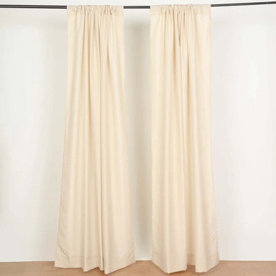Cream-colored curtain panels hanging from a black rod.
