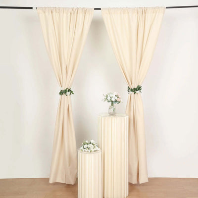 Cream curtains with floral accents and decorative pedestals.