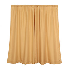 A pair of gold polyester solid backdrop curtains on a white background