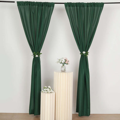 Green curtains draped elegantly with floral accents in a staged setting.