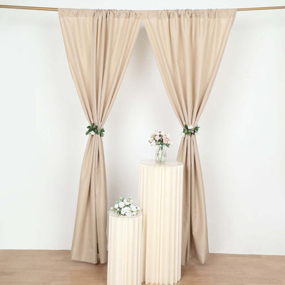 Beige curtains with floral accents and decorative tables in a staged setting.
