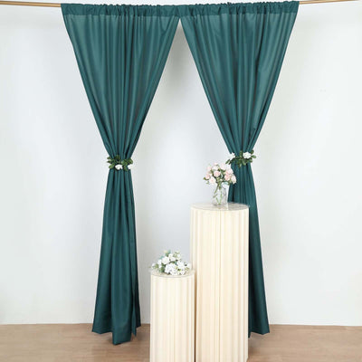 Teal curtains draped elegantly with floral accents on pedestals.