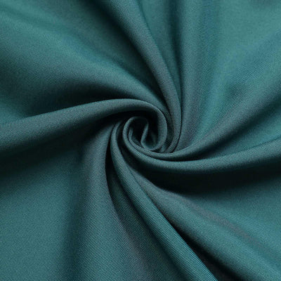 Teal fabric texture in a swirling pattern.