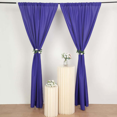 Purple curtains draped elegantly with floral accents on pedestals.