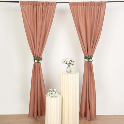 Two elegant brown curtains with flower accents, styled with decorative pedestals.