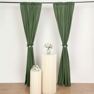 Green curtain set displayed elegantly with decorative vases on pedestals.