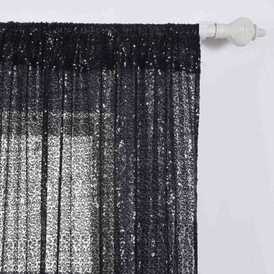 Black sequin curtain panel hanging from a white rod