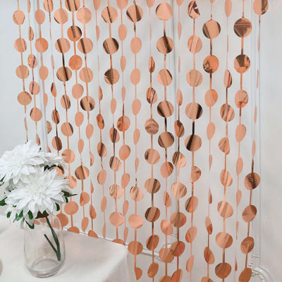 Rose gold circle curtain decor with white flower arrangement.