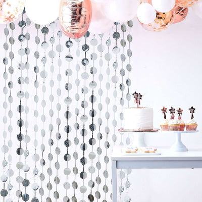 Decorative backdrop with balloons and a cake for a festive celebration.
