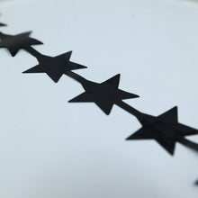 A row of black metallic foil star shaped curtains on a white background#whtbkgd