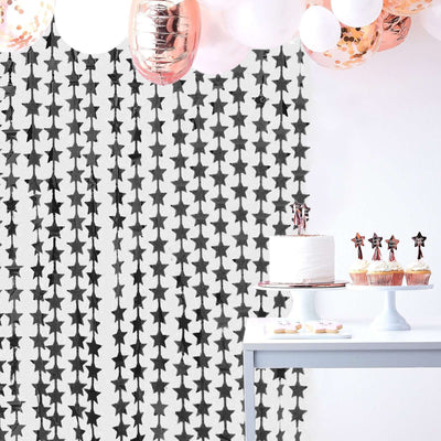 Birthday party setup with cake, cupcakes, and star-patterned backdrop.