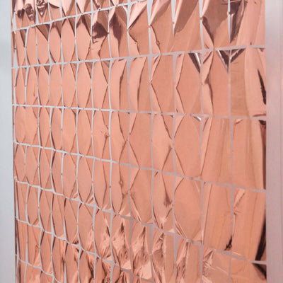 Rose gold mirrored tiles arranged in a geometric pattern.