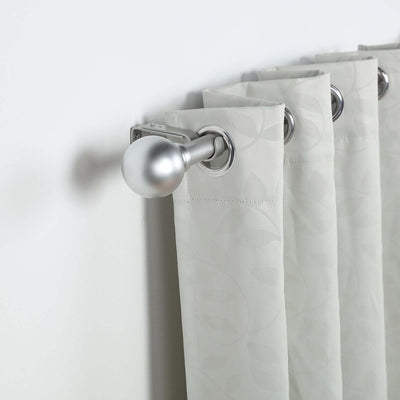 Silver curtain rod with textured gray curtains hanging on a white wall.