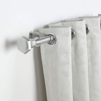 Silver curtain rod with hexagonal finial and patterned gray curtains
