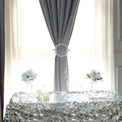 Elegant table setup with sequin tablecloth and floral arrangements.