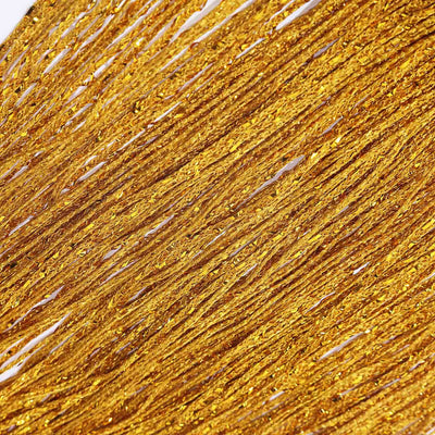 Shimmering gold fringe material on a white background