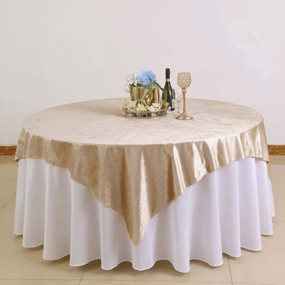 Round table with a champagne-colored tablecloth and floral centerpiece