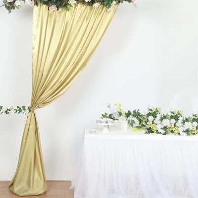 Elegant golden curtain draped with flowers beside a decorated table.