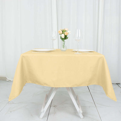 Elegant beige tablecloth on a dining table with floral centerpiece and glassware.