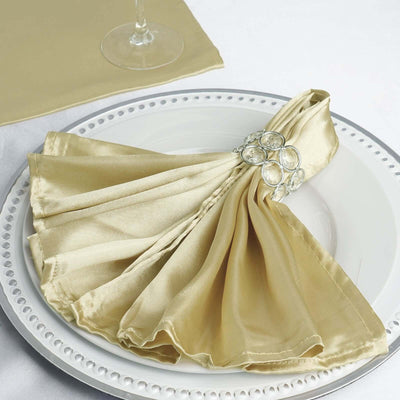 Elegant gold satin napkin elegantly arranged on a decorative plate.