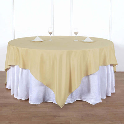 Round gold tablecloth on a white table with glassware and napkins
