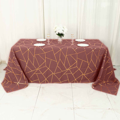 Geometric patterned tablecloth in burgundy and gold on a dining table.