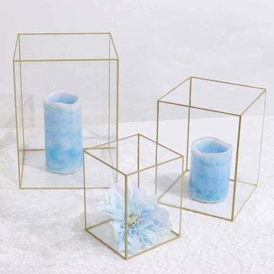 Glass candle holders with blue candles and flowers, studio-style isolation shot.