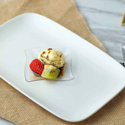 Dessert with ice cream, strawberries, and kiwi on a white plate.