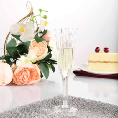 Elegant champagne flute filled with bubbly, set against flowers and a cake.