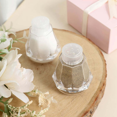 Salt and pepper shakers on a wooden surface with flowers and a gift box.