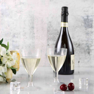 Chilled sparkling wine with glasses, ice cubes, and cherries on a table.