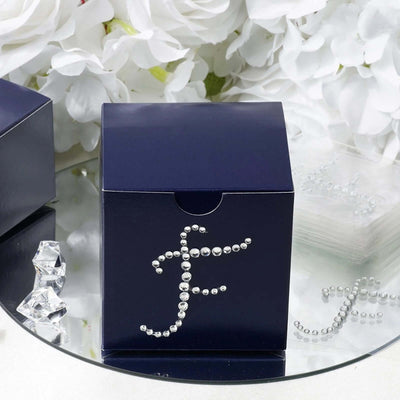 Navy gift box adorned with rhinestones on mirrored surface