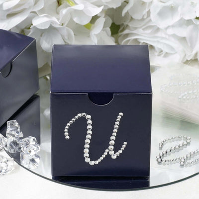 Navy gift box with rhinestone embellishment on a mirrored surface.