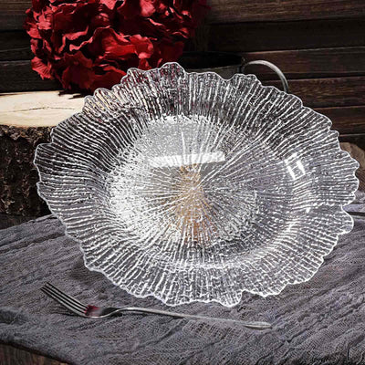 Decorative clear glass plate with textured floral design on rustic background.