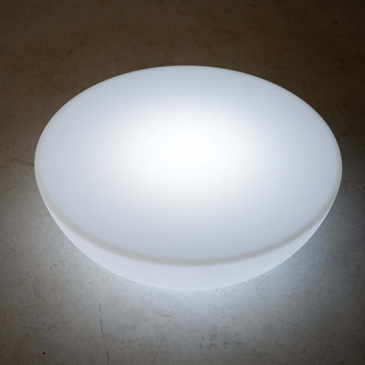 Round glowing white bowl light on a plain surface.