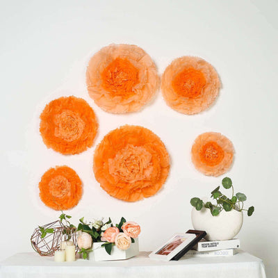 Orange paper flower wall decor arrangement with floral accents and greenery.