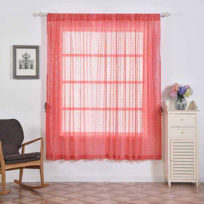Coral sheer window curtain in a cozy room setting with a chair and floral decor.