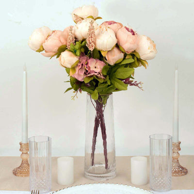 Elegant floral arrangement in a glass vase with soft pink peonies and green accents.