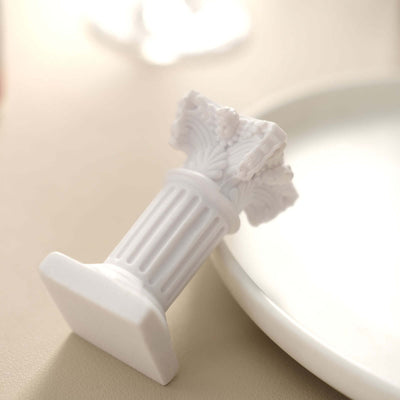 White decorative column figurine on a beige surface.