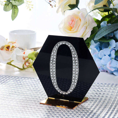 Black hexagonal table number "0" with rhinestones, elegant decor piece.