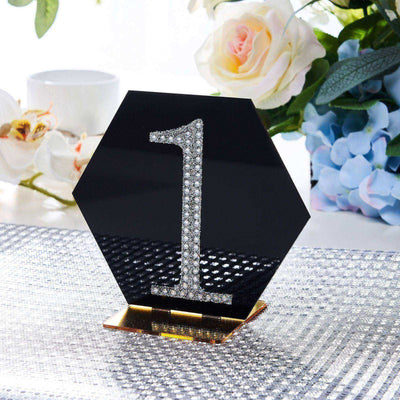 Black hexagon table number stand with rhinestone embellishments, elegant decor piece.