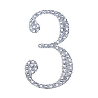 Decorative silver number three with polka dots on a white background