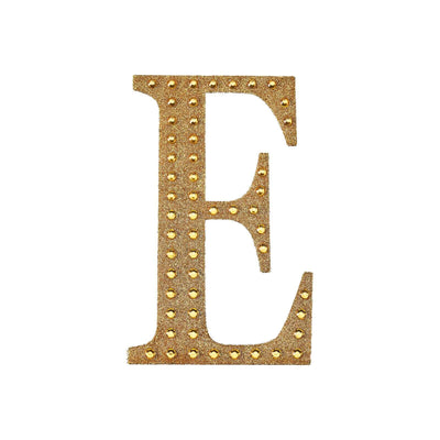 Gold studded letter "E" on a white background.