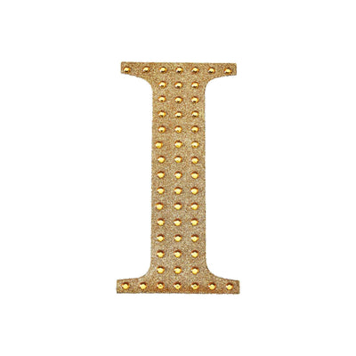 Gold letter "I" with studded design on a plain white background.