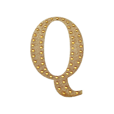Gold marquee letter Q with lights on a white background.