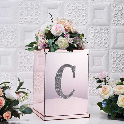 Decorative floral arrangement in a mirrored box with a rhinestone letter "C"