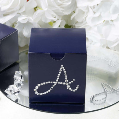 Navy gift box adorned with rhinestones in a decorative letter "A" design.